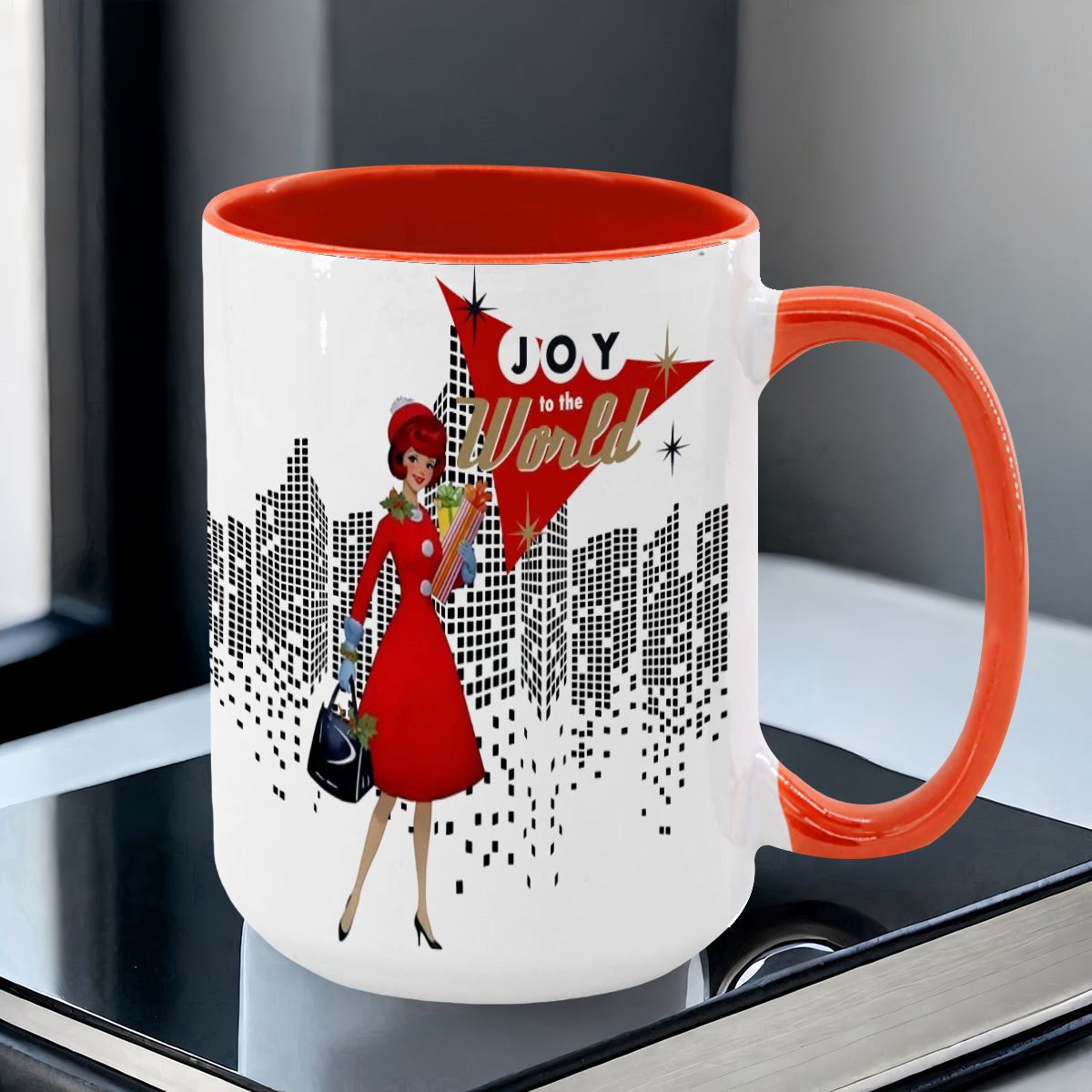 Mid Century Modern holiday mug featuring a cityscape design and a retro woman in red with "Joy to the World" text.