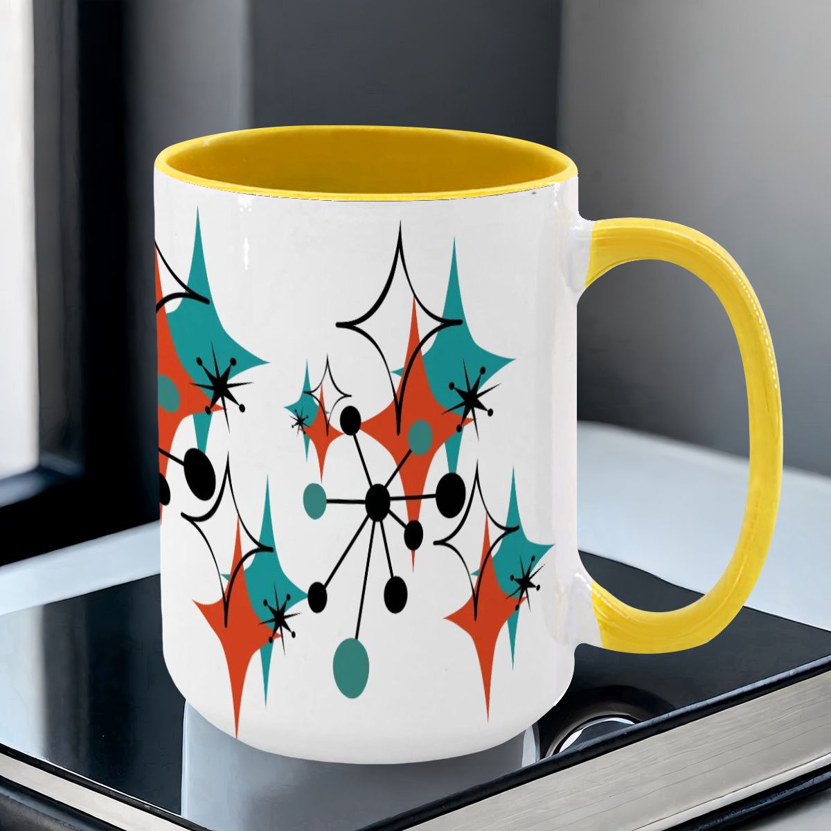 Large 15oz mug featuring a colorful Mid Century Modern atomic starburst design in teal, orange, and black with a yellow handle.