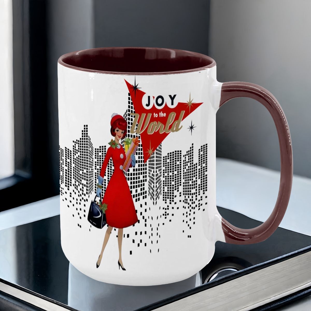 Mid Century Modern holiday mug featuring a cityscape design and a woman in a red dress holding gifts with "Joy to the World.