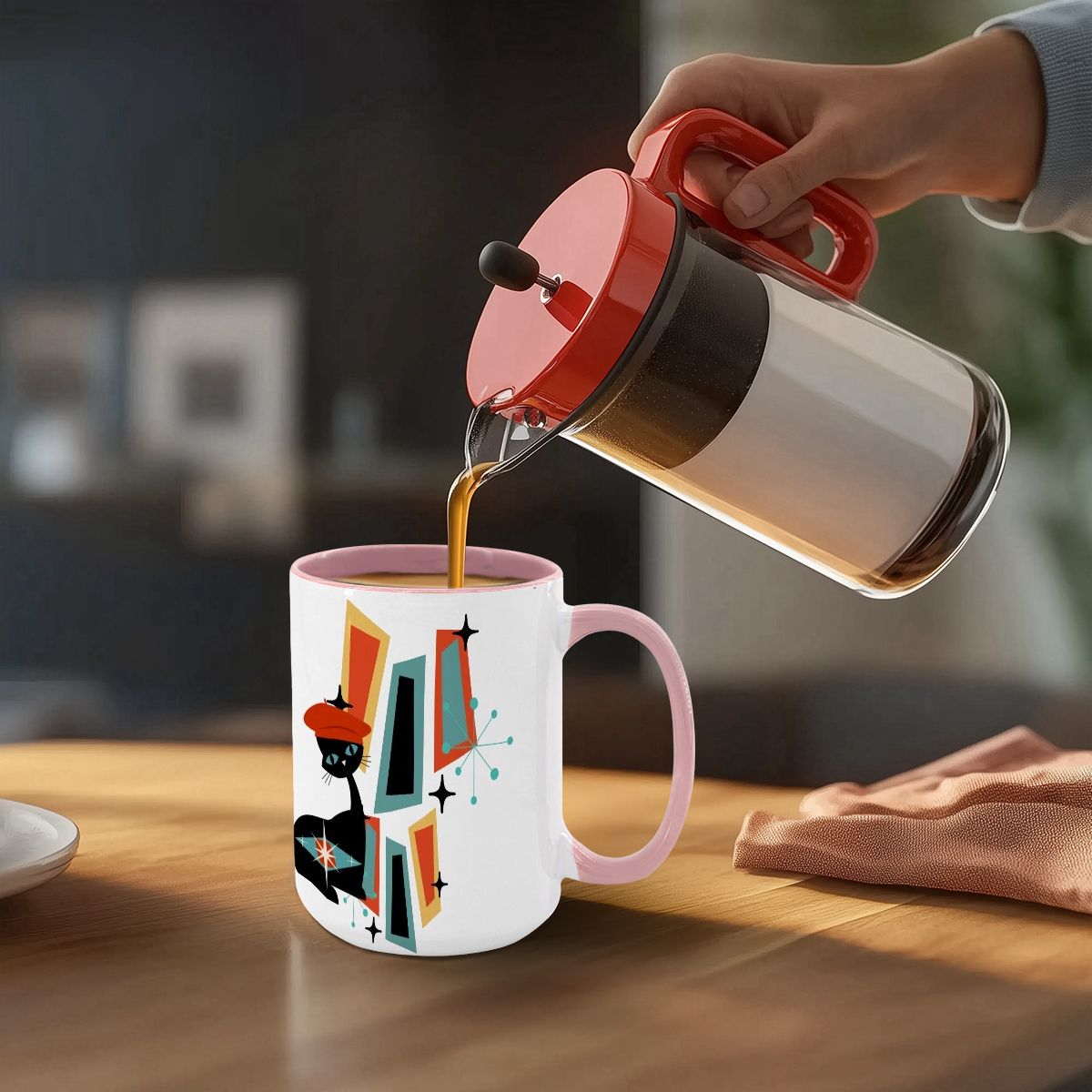Mid Century Modern coffee mug featuring an atomic cat and geometric design, with coffee being poured into it.