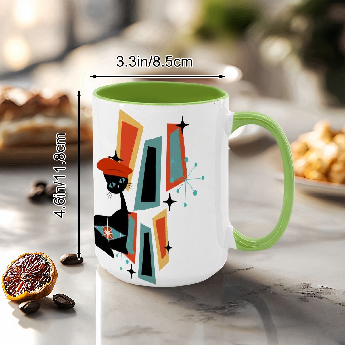 Mid Century Modern coffee mug featuring an atomic cat design with geometric shapes and a vibrant green handle.