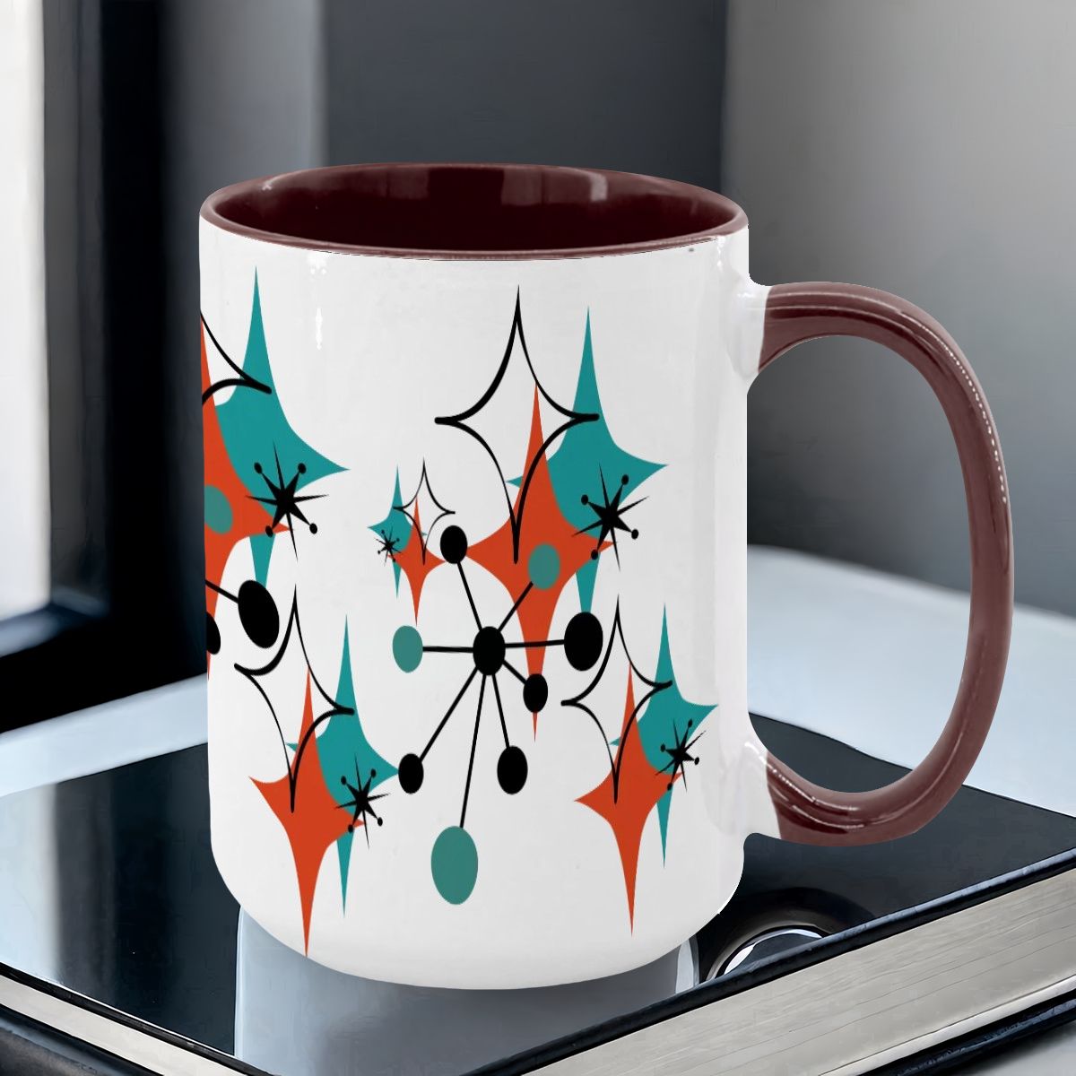 Colorful 15oz mug featuring a Mid Century Modern atomic starburst design in teal, orange, and black on a white background.