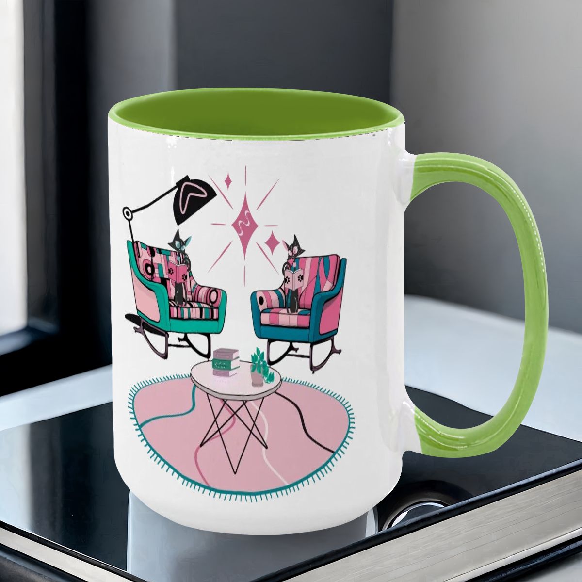 Large colorful mug featuring atomic reading cats in mid-century modern chairs, with a vibrant green handle and interior.